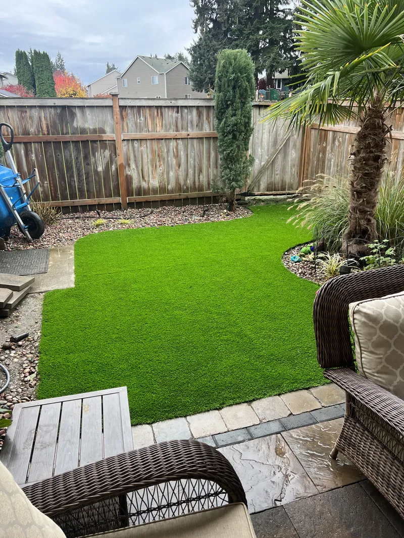 Backyard with paver accents and synthetic turf